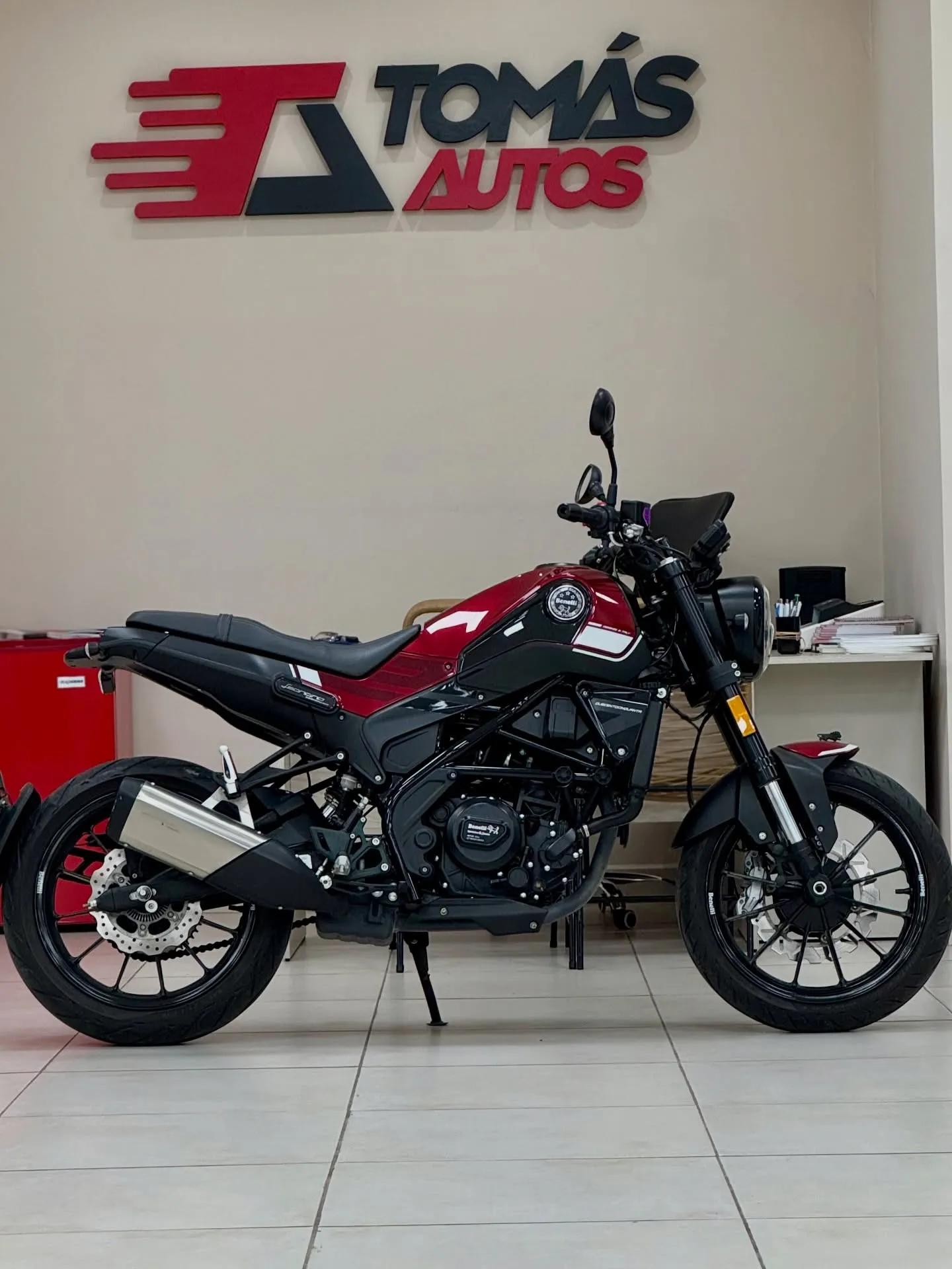 Moto Benelli Leoncino 250 2022 roja y negra, de perfil, en el showroom de Tomás Autos