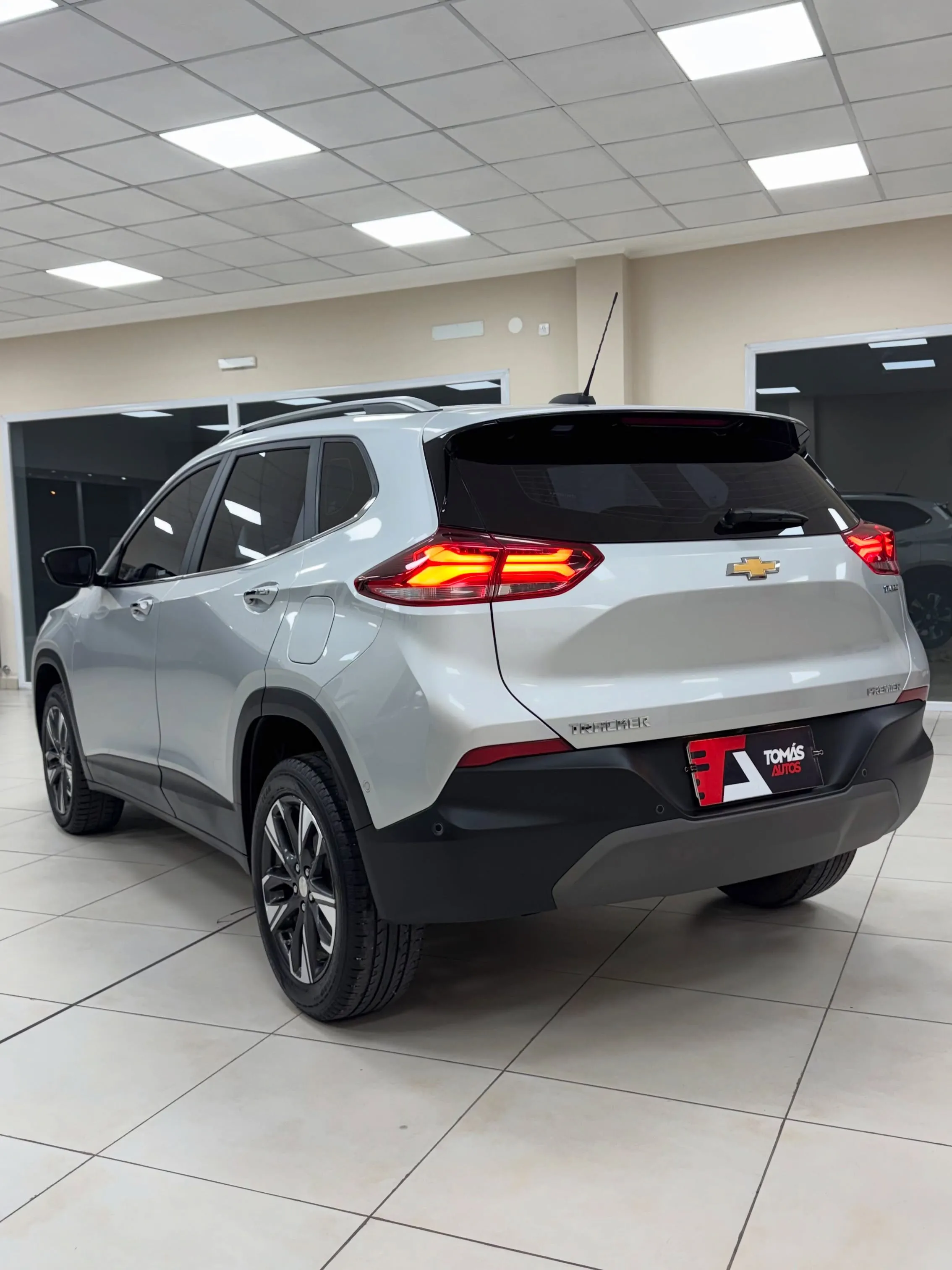 Chevrolet Tracker Premier 2022 blanca, de atrás y perfil izquierdo, con las luces encendidas